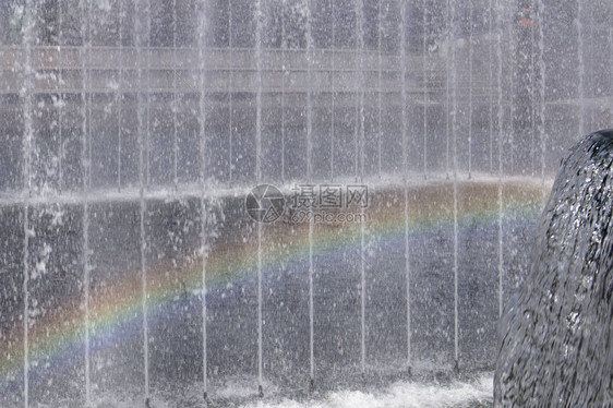 有彩虹和大杯水流在侧面的喷泉气图片