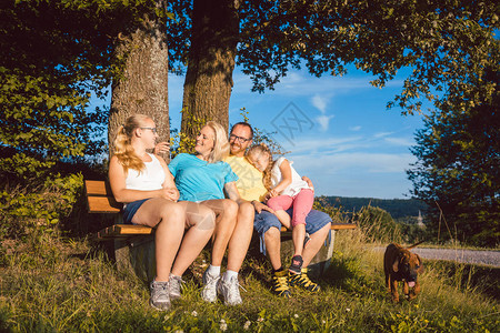快乐的家庭在夏季长途跋涉时坐图片