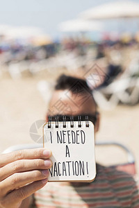 海滩上一个年轻天主教男子的剪贴展示了一个螺旋笔记上面写着我要在首页图片