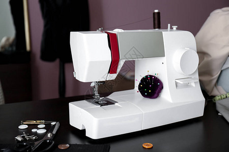裁缝车间桌子上有配件的缝纫机图片