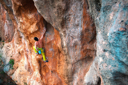 一个人爬上岩石在大自然中攀爬户外健身积极的生活方式极限员在自图片