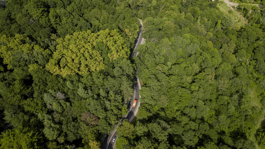 汽车沿着蜿蜒的山口公路穿过俄罗斯索契森林的空中库存照片图片