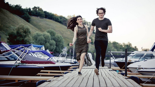 浪漫的情侣正在码头上奔跑夏天的背景图片