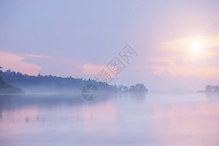 随着日出湖面上的薄雾正在蔓延到地平线图片
