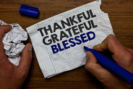 文字书写文本感恩祝福感恩好心情的商业理念手握纸吊和蓝色标记木图片