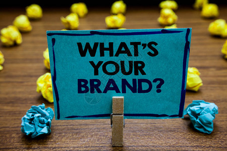 手写文本什么是您的品牌问题概念含义定个人商标识别公司模糊木甲板黄色和蓝色吊球在地面纸夹背景图片