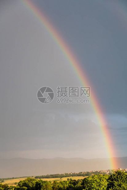 自然界概念彩虹在古村和草原上雨后复图片