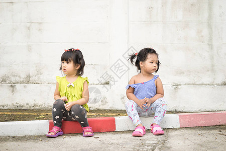 两个坐在不同边的小女孩不看对方也不说话图片