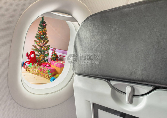 飞机窗和圣诞装饰品在木头图片