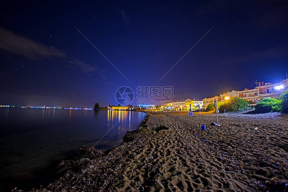 在希腊哈尔基迪夜海滩的浪漫户外摄影沙滩海水中彩色照明和图片