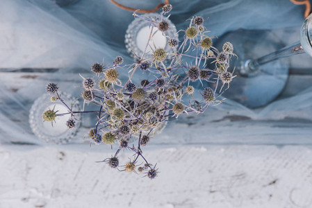 植物茶烛和纯蓝色织物作为婚礼桌布图片