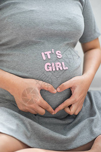 孕妇用手势作为腹部的心脏图片