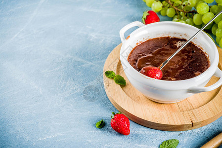 草莓葡萄和猕猴桃的甜果味巧克力火锅甜点图片