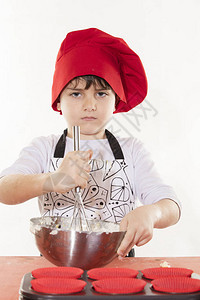 可爱的小衣服厨师男孩准备纸杯蛋糕图片