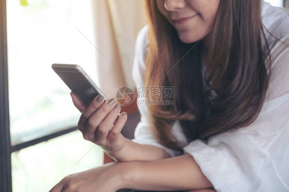 使用和触摸智能手机的亚洲女抱持使用和触碰智能电图片