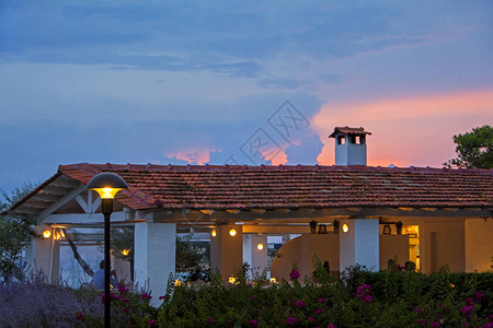 海边地中海餐厅古典瓦顶上的美丽日落背景图片