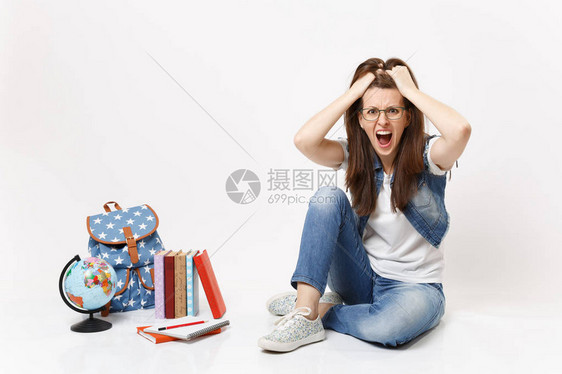 年轻的疯狂愤怒的女学生穿着牛仔服尖叫着紧贴着头部坐在附近图片