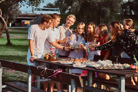一群快乐的朋友一起在户外公园庆祝生日快乐的朋友在户外野餐派对图片