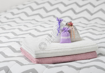 芳香的百花香摆在床上毛巾上的三个薰衣草香味袋卧室里的香包清新香氛袋装饰家背景图片