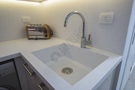 在豪华公寓展厅显示现代厨房水槽和烤面包机的内部图片