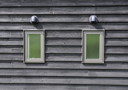 木墙上洗手间的两扇绿色小窗图片