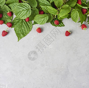 新鲜和成熟的草莓有绿色叶子在混凝土背景图片