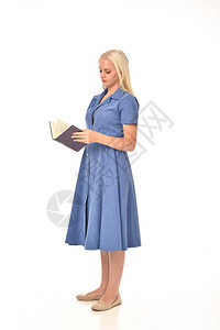 穿着蓝裙子的金发女孩的全长肖像站立姿势拿着一本书孤立在白色图片