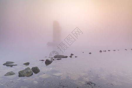 在荷兰泽的三角洲工程风暴潮海障NeeltjeJans的浓雾冬季日落期间图片
