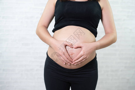孕妇双手在腹部呈心形图片