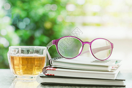 螺旋笔记本上的眼镜和茶杯其天然图片