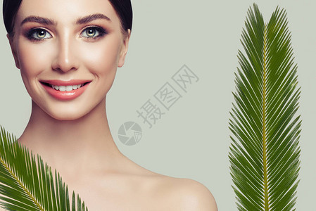 女脸和绿叶Spa女人模型与健康的皮肤和可爱的微笑面部护理美图片