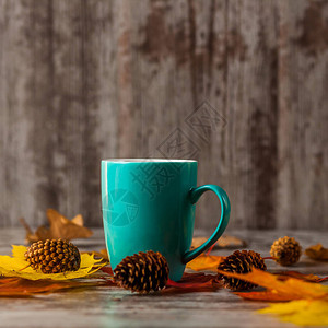 蓝杯茶在黄红叶的木制图片