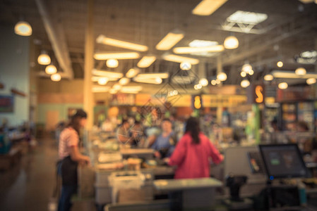 人们结帐柜台的收银台线模糊顾客在超市向店员支付信用卡员工协助收银台销售柜台电脑背景图片
