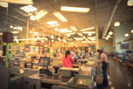 人们结帐柜台的收银台线模糊顾客在超市向店员支付信用卡员工协助收银台销售柜台电脑背景图片