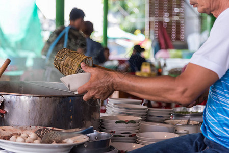 亚洲厨师在泰国街头食品市场或餐馆做汤和肉球kauy图片
