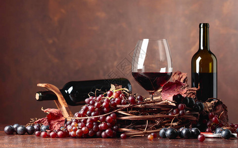 红酒和新鲜葡萄有干枯的藤叶图片