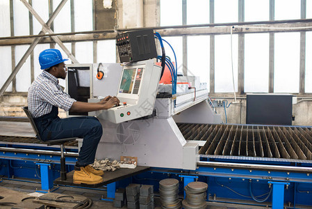 现代工厂生产部高专业工人穿着整体和安全帽操作机器图片