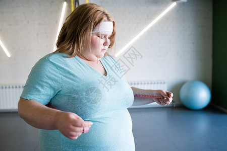 躲避体操中体重减瘦后腰部大小的肥胖女青年图片