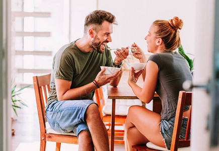 年轻夫妇在饭厅餐桌上吃谷物早图片