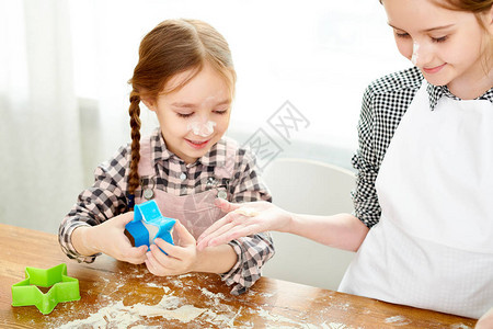 可爱的小女孩通过饼干切割机图片