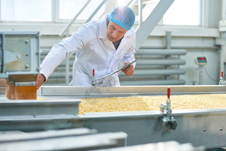 食品行业高级工厂人检查生产过程的画像图片