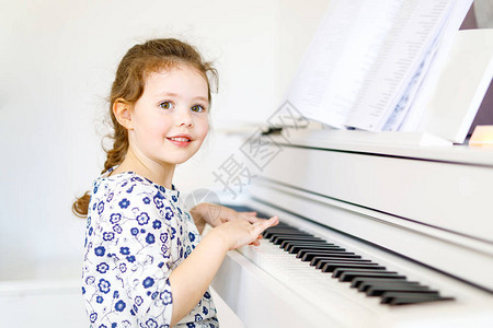 可爱健康的小女孩在客厅或音乐学校弹钢琴学龄前儿童学习演奏乐器很开心教图片