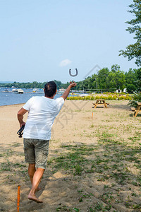 成年男子投掷马蹄铁游戏海滩活动图片