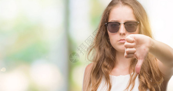 穿着太阳眼镜的金发年轻女人看上去不开心愤怒拒绝和否定图片