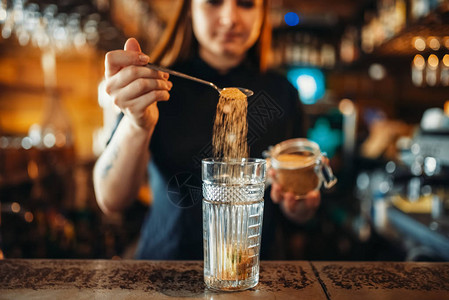 女酒保在酒吧的酒吧柜台混杂图片