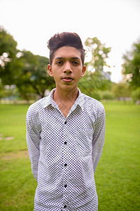 在泰国曼谷市公园放松的印度少年肖像图片