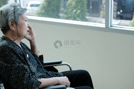坐在轮椅上的老妇人用手机说话老年女在智能手机上发言前图片