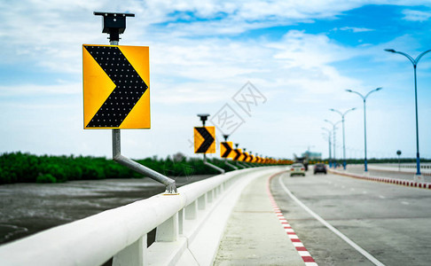 桥上的曲线交通标志上黑黄箭头图片