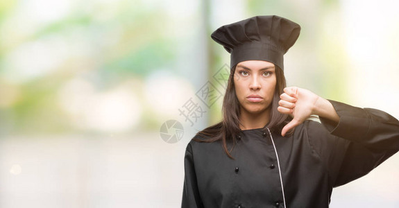 身着厨服脸愤怒反面表情迹象表示不喜欢用拇指往下伸缩拒绝概念的年轻图片