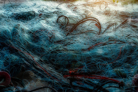 阳光下海滩上的旧渔网图片